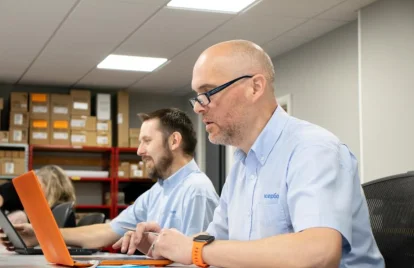 two men using laptops